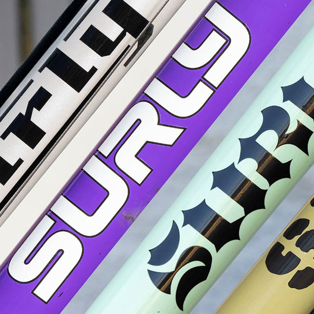 Collage image of different Surly decals on different color bike down tubes