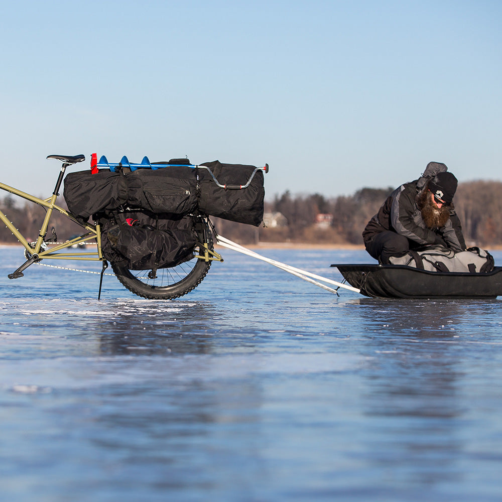 Hauling ice fishing gear and sled on frozen lake