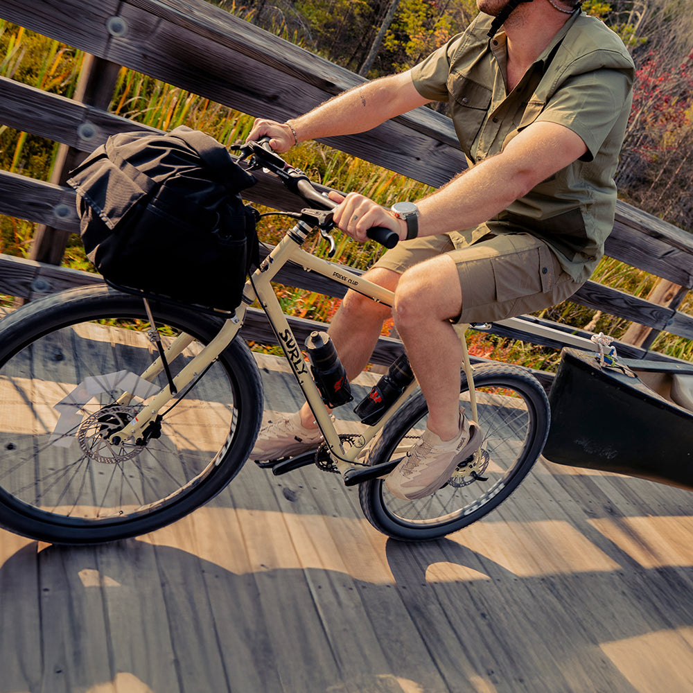 Person riding Surly Bridge Club bike on bridge towing canoe