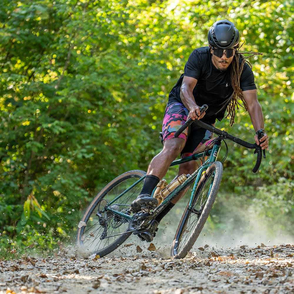 Cyclist riding Surly Straggler and skidding on gravel road