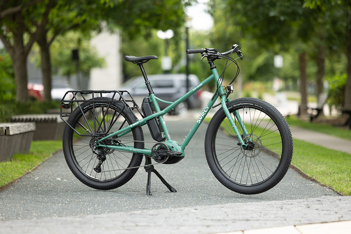 Surly Skid Loader Ebike side view parked on sidewalk outside with dual kickstant